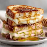 Golden-brown smoked gouda apple grilled cheese sandwich served hot on rustic ciabatta slices.
